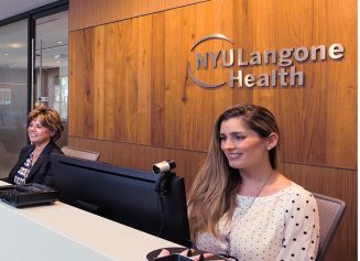 Two female staff members work at their computers at our Patient Access Center in Florida.