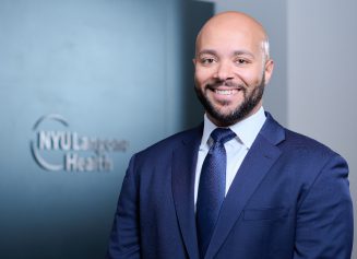 A smiling male staff member at the NYU Langone Health Patient Access Center and Business Office in Nevada.