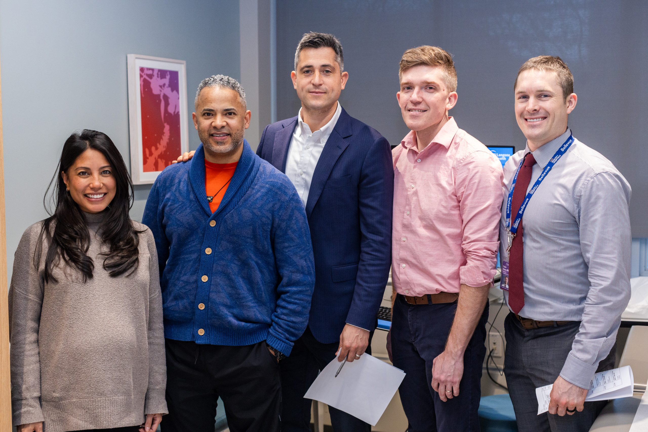 Staff members standing together, smiling in an office.